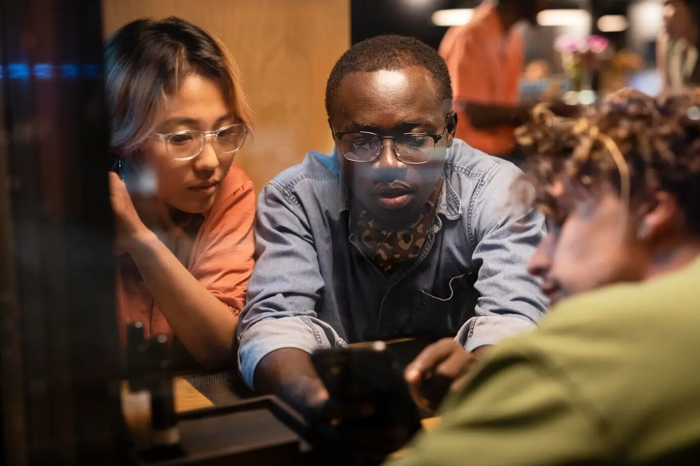 Nahaufnahme von Menschen, die auf ein Smartphone schauen