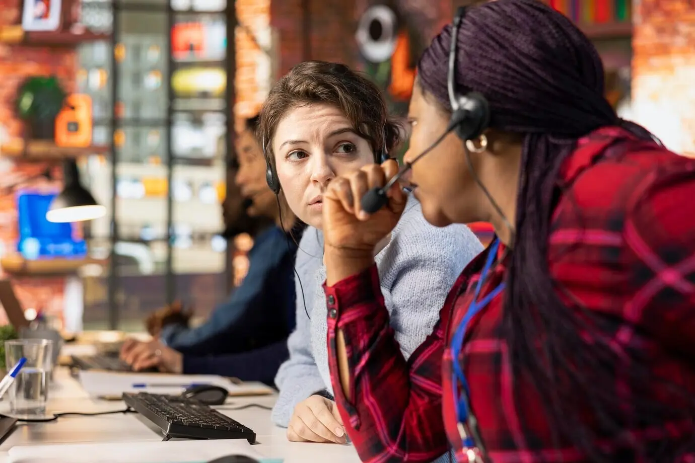 Mitarbeiter eines Kundencenters arbeiten zusammen, um Kunden bei der Installation von Software zu unterstützen.